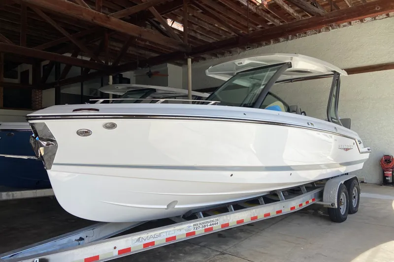 The Image of 2027 Monterey Elite 27 OB boat on trailer in covered storage area. - 0