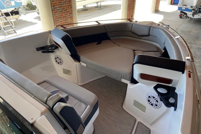 Slide: The Image of Luxurious seating area of 2027 Monterey Elite 27 OB boat with cup holders and speakers. - 17