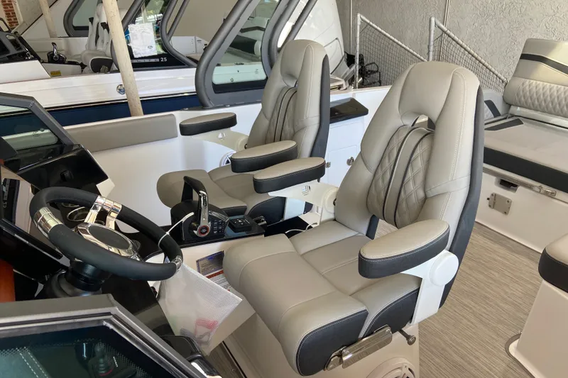 Slide: The Image of Luxury seating and helm of 2027 Monterey Elite 27 OB boat interior. - 16