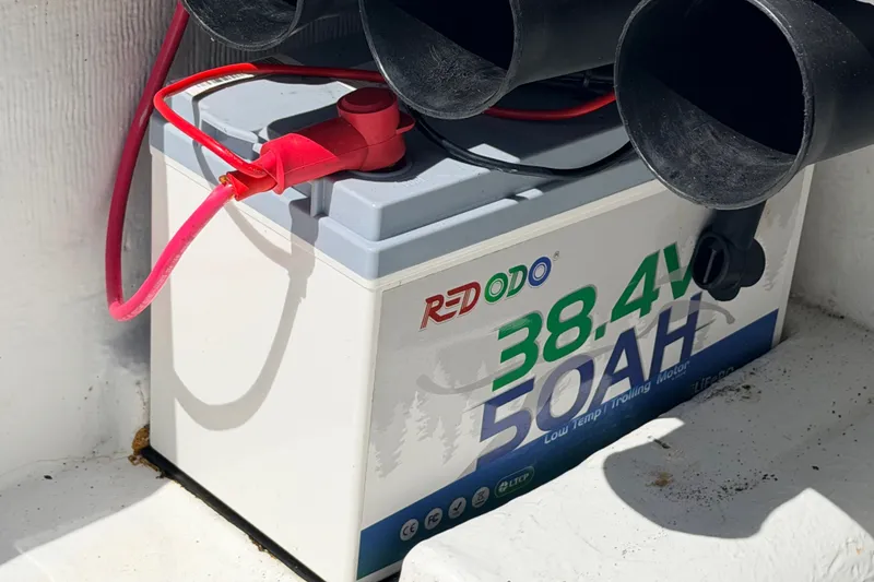 Slide: The Image of Battery with red cable, labeled "REDODO 38.4V 50AH," in a NewWater Ibis 2011 boat. - 33