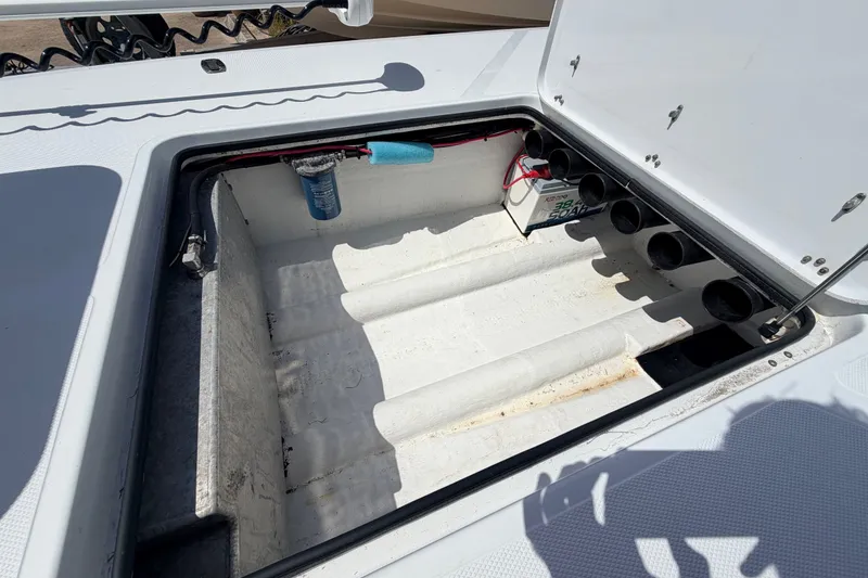 Slide: The Image of Open storage compartment in 2011 NewWater Ibis boat, featuring battery and wiring setup. - 31