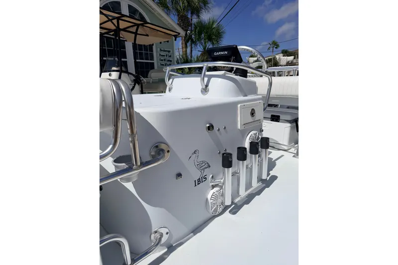 Slide: The Image of 2011 NewWater Ibis boat console with Garmin device, rod holders, and palm trees in the background. - 20
