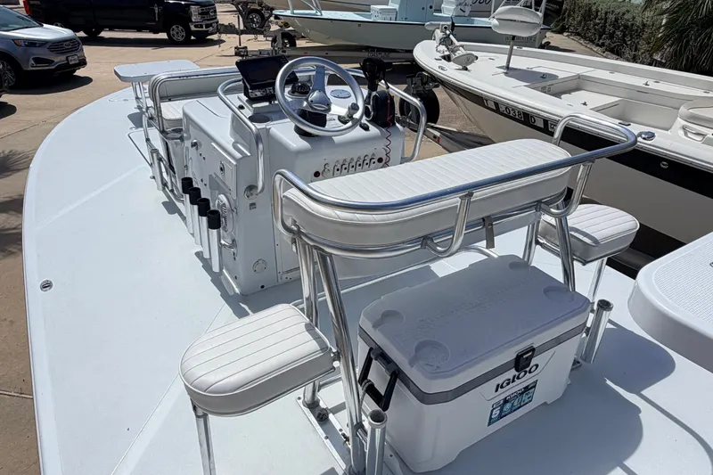 Slide: The Image of 2011 NewWater Ibis boat interior with steering console, seating, and cooler on deck. - 17