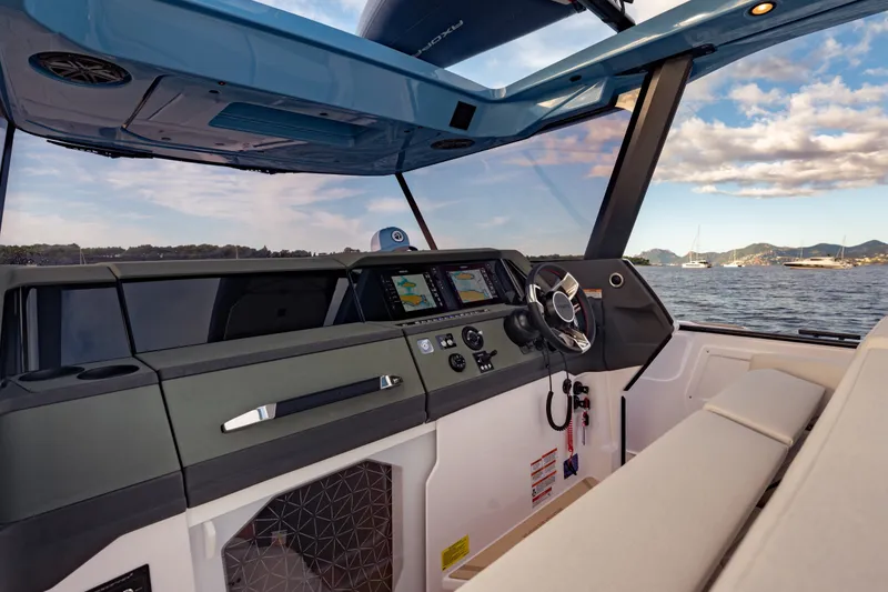 Slide: The Image of Interior view of 2027 Axopar 38 Cross Top boat with modern dashboard and scenic ocean backdrop. - 29