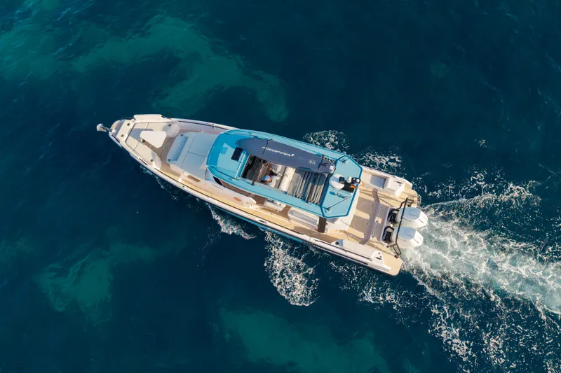 Slide: The Image of Aerial view of 2027 Axopar 38 Cross Top cruising on clear blue water. - 10