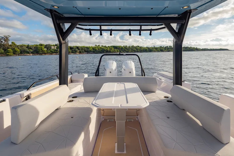 Slide: The Image of Luxurious seating area on 2027 Axopar 38 Cross Top boat, overlooking serene waters. - 24