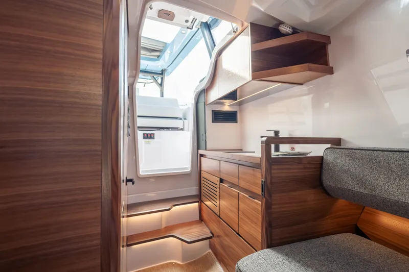 Slide: The Image of Interior of 2027 Axopar 38 Cross Top boat, featuring sleek wood cabinetry and modern design. - 32