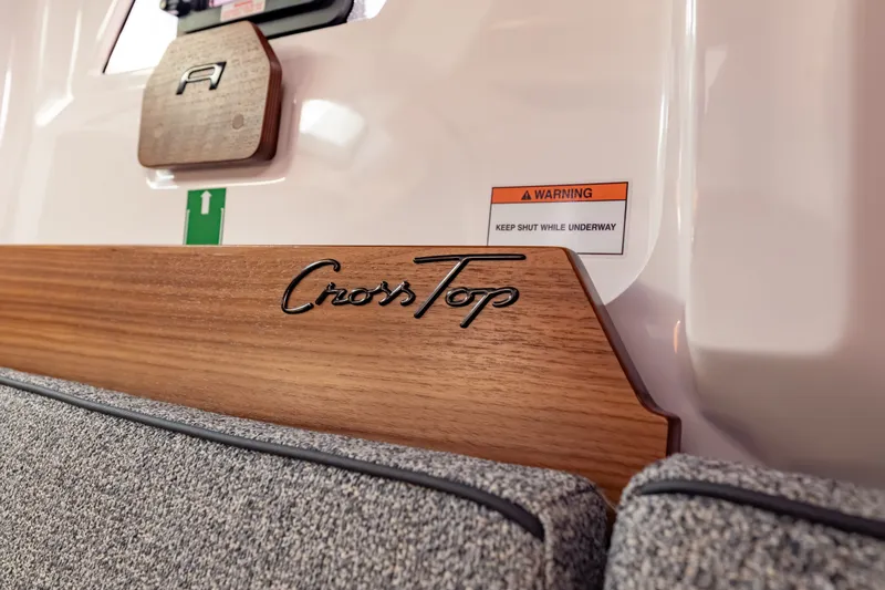 Slide: The Image of 2027 Axopar 38 Cross Top interior detail with wood finish and safety warning. - 34