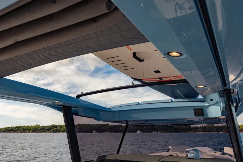 Slide: The Image of 2027 Axopar 38 Cross Top boat with open roof, scenic water view. - 17