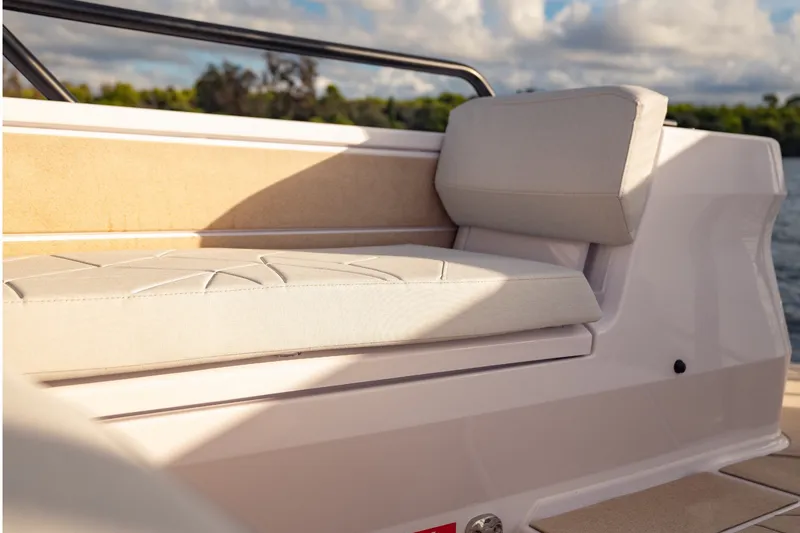 Slide: The Image of 2027 Axopar 38 Cross Top boat interior with cushioned seating and scenic sky view. - 22