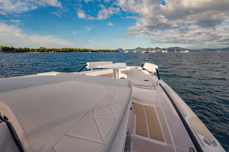 Slide: The Image of 2027 Axopar 38 Cross Top boat on serene water with scenic horizon. - 19