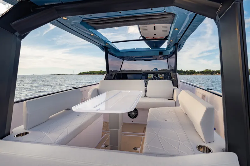 Slide: The Image of Luxurious interior of 2027 Axopar 38 Cross Top boat with white seating and table. - 25