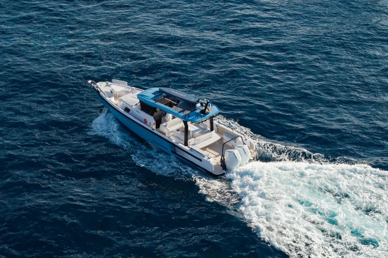 Slide: The Image of 2027 Axopar 38 Cross Top cruising on open water, aerial view. - 3