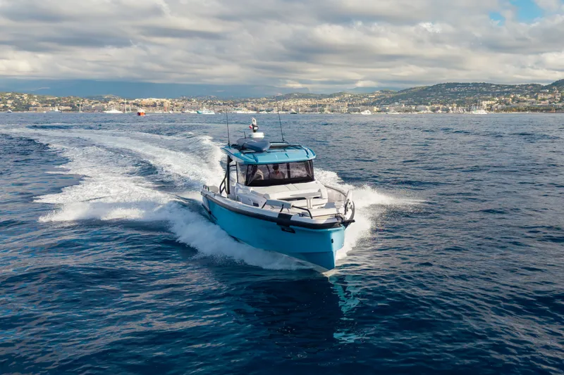 Slide: The Image of 2027 Axopar 38 Cross Top cruising on open water under cloudy skies. - 7