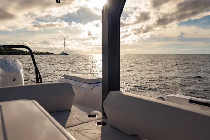 Slide: The Image of 2027 Axopar 38 Cross Top boat on serene ocean at sunset. - 27