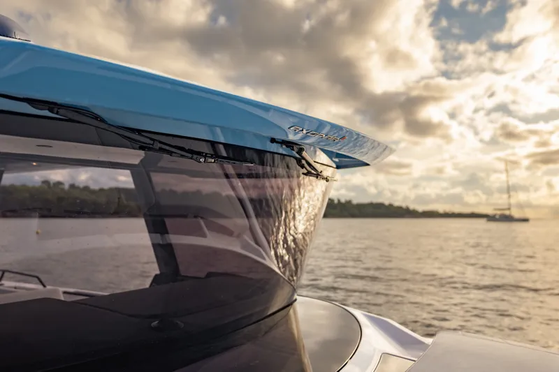 Slide: The Image of 2027 Axopar 38 Cross Top boat on serene water at sunset. - 13