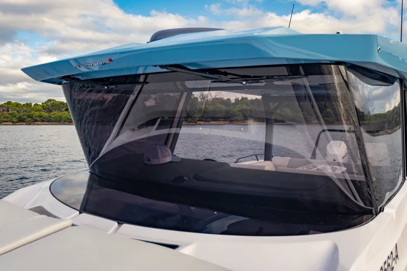 Slide: The Image of 2027 Axopar 38 Cross Top boat on water, featuring sleek design and modern canopy. - 12