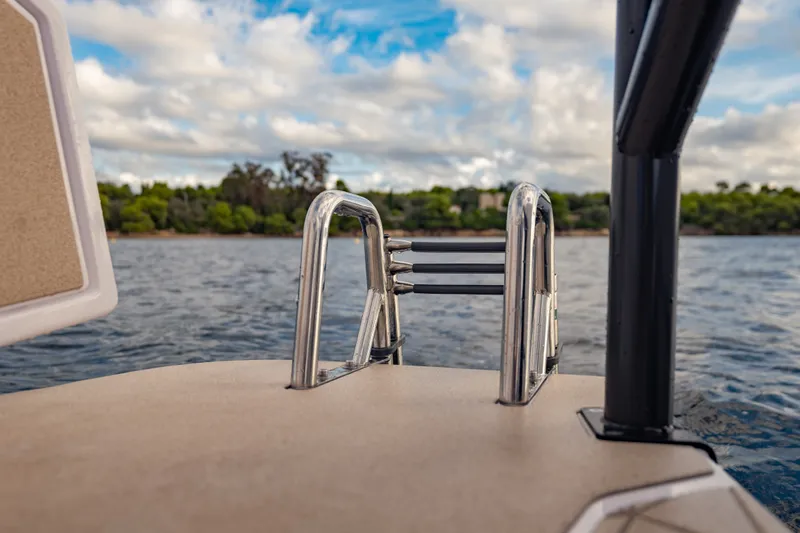 Slide: The Image of Rear view of 2027 Axopar 38 Cross Top boat ladder by the water. - 23