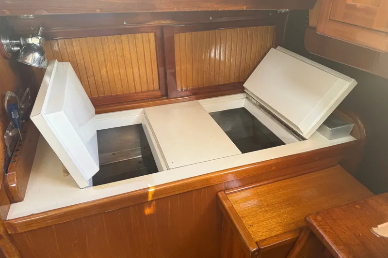 Slide: The Image of Interior of 1965 Hinckley Yachts Bermuda 40, featuring wooden cabinetry and open storage compartments. - 14