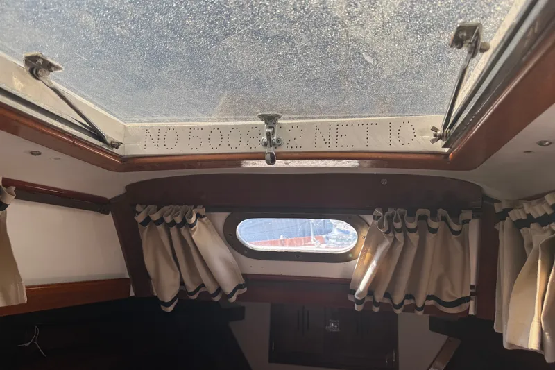 Slide: The Image of Interior view of a 1965 Hinckley Yachts Bermuda 40 cabin with curtains and a hatch. - 18