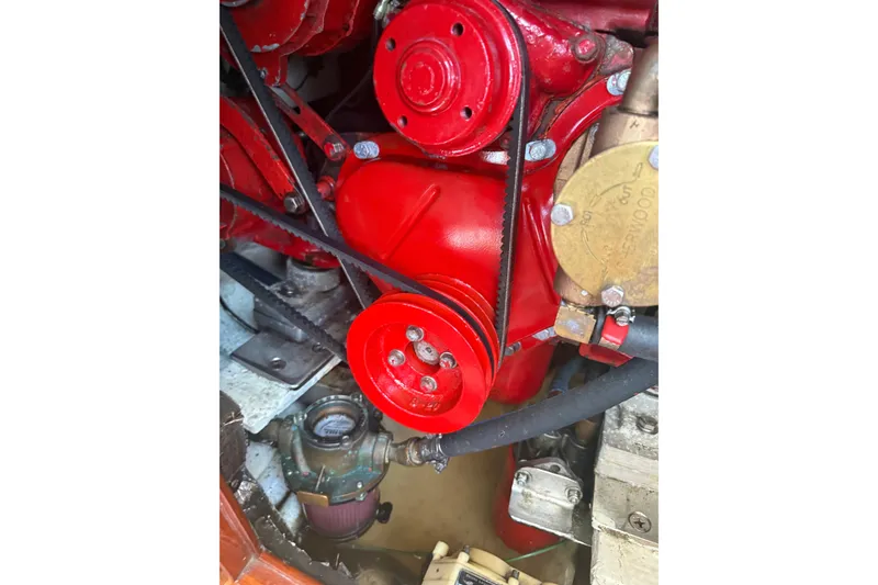 Slide: The Image of Engine components of a 1965 Hinckley Yachts Bermuda 40, featuring red pulleys and belts. - 23
