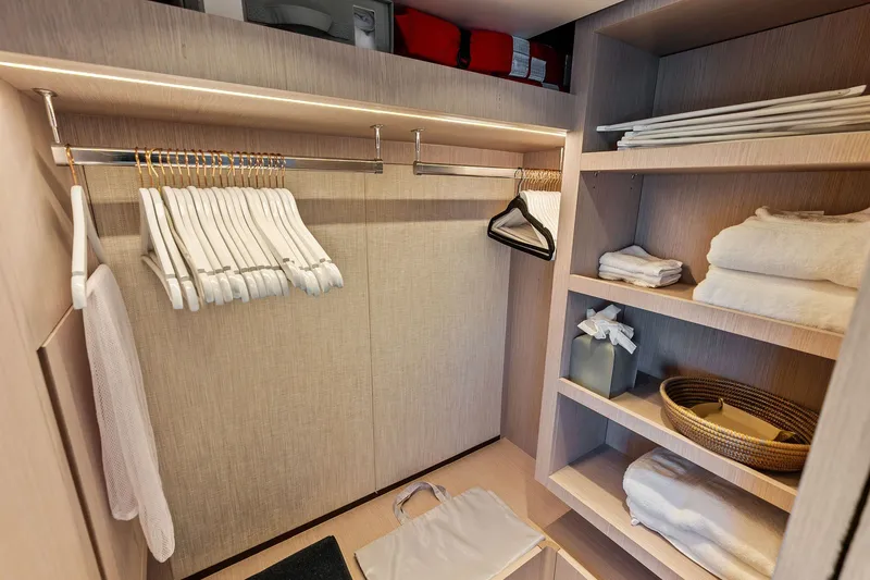 Slide: The Image of Luxurious closet interior on 2024 Ferretti Yachts 860, featuring hangers and neatly arranged shelves. - 78