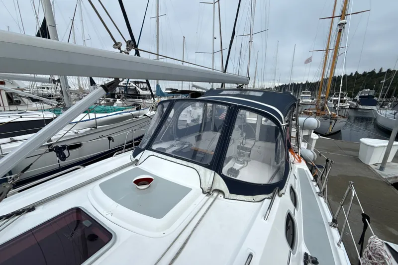 Slide: The Image of 2010 Hunter 36 sailboat docked at marina, featuring a covered cockpit and sleek design. - 34