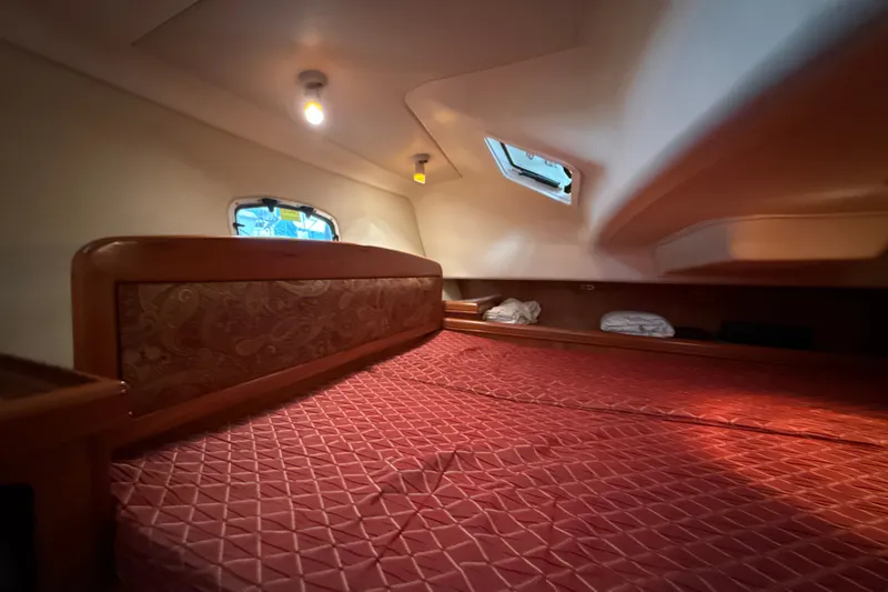 Slide: The Image of Cozy cabin interior of 2010 Hunter 36 sailboat with red bedding and natural light. - 16