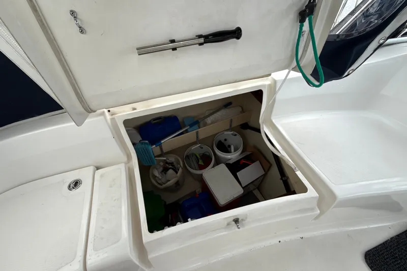 Slide: The Image of Open storage compartment on a 2010 Hunter 36 boat, containing various boating supplies. - 24