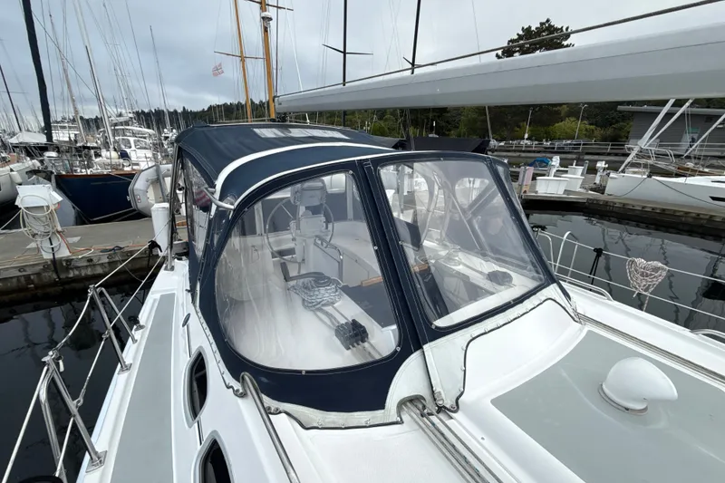 Slide: The Image of 2010 Hunter 36 sailboat docked at marina, featuring a covered cockpit and sleek design. - 31