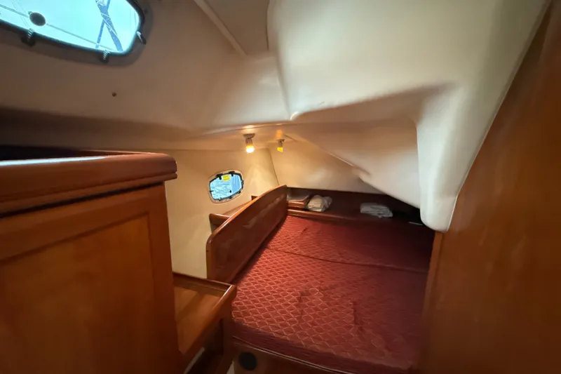 Slide: The Image of Cozy cabin interior of 2010 Hunter 36 sailboat with red bedding and wooden furnishings. - 17