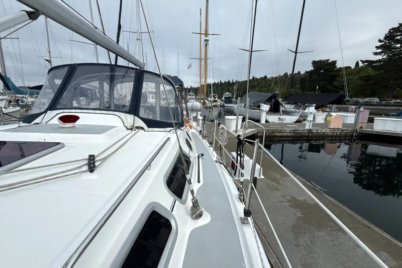 Slide: The Image of 2010 Hunter 36 sailboat docked at a marina, showcasing sleek design and rigging. - 33