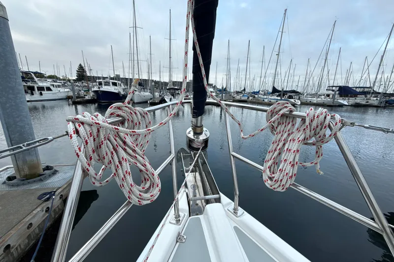 Slide: The Image of Bow view of a 2010 Hunter 36 sailboat docked in a marina with coiled ropes. - 38