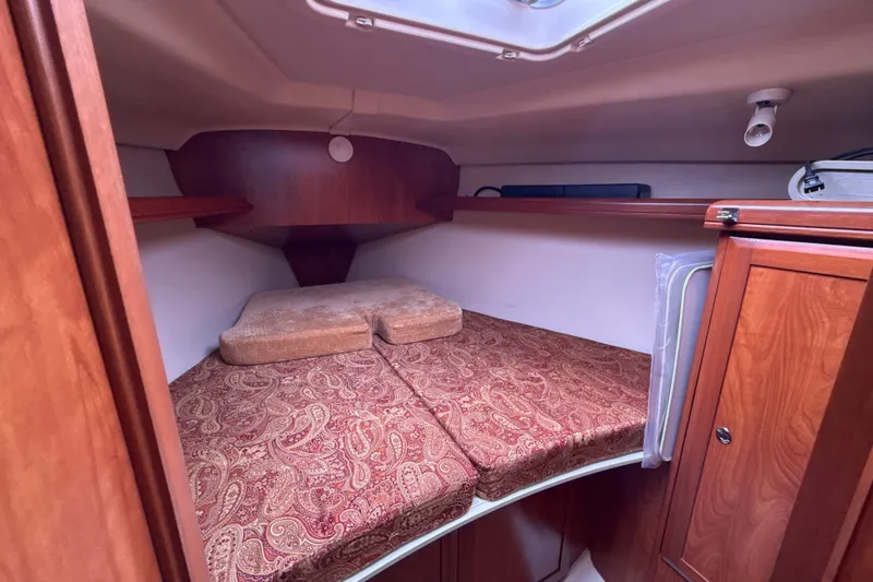 Slide: The Image of Cozy cabin interior of 2010 Hunter 36 sailboat with patterned cushions and wooden cabinetry. - 19