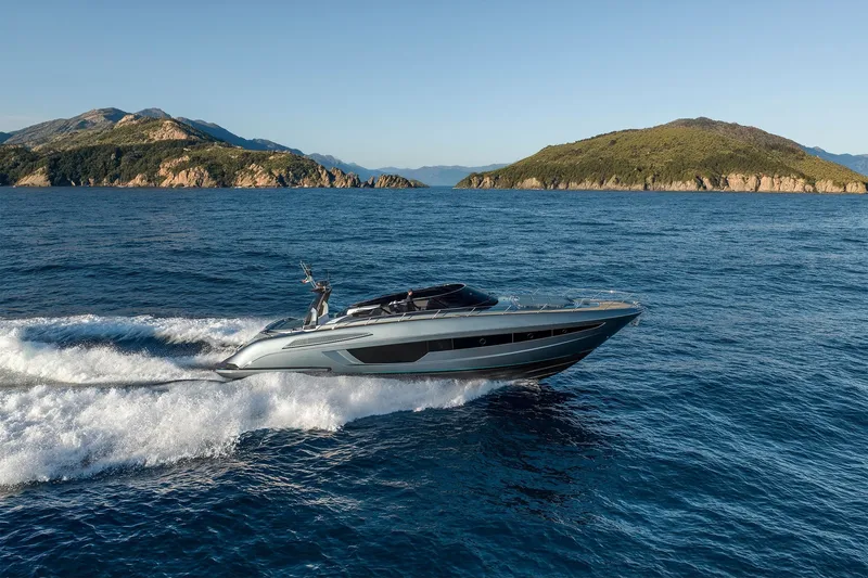 Slide: The Image of Luxury 2027 Riva 56' Rivale yacht cruising on open sea near scenic islands. - 2