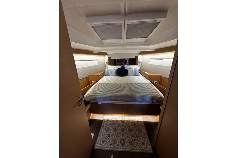 Slide: The Image of Luxurious cabin interior of 2022 Jeanneau Sun Odyssey 440 yacht, featuring a cozy bed and elegant design. - 7