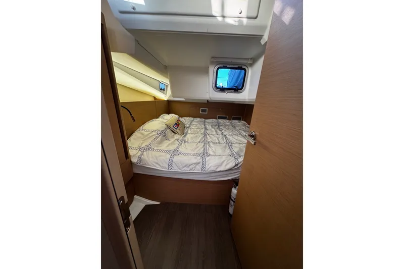 Slide: The Image of Cozy cabin interior of 2022 Jeanneau Sun Odyssey 440 sailboat with bed and window. - 11