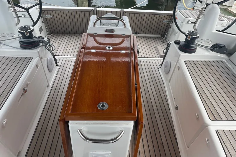 Slide: The Image of Cockpit of 2022 Jeanneau Sun Odyssey 440 with wooden table and steering wheels. - 21