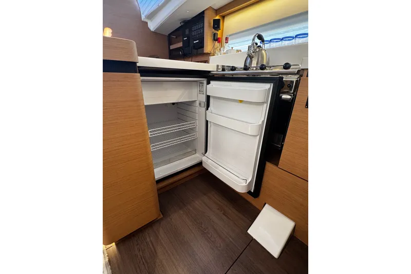Slide: The Image of Interior view of Jeanneau Sun Odyssey 440 yacht kitchen, featuring an open refrigerator. - 6