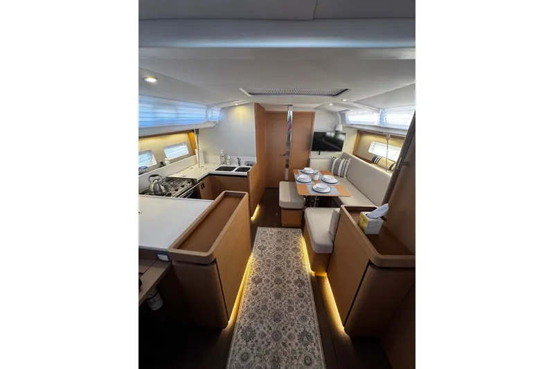 Slide: The Image of Interior of 2022 Jeanneau Sun Odyssey 440 yacht, featuring modern kitchen and dining area. - 1