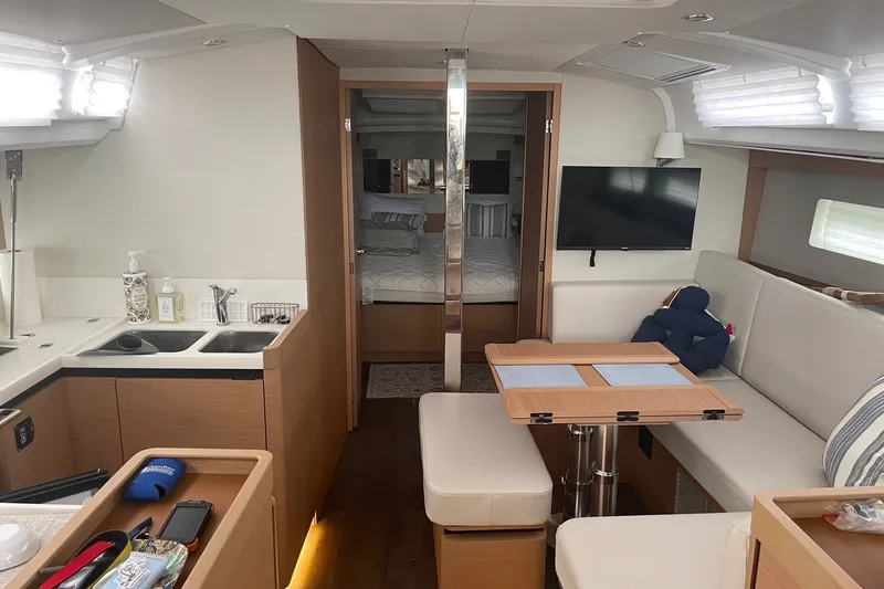 Slide: The Image of Interior of 2022 Jeanneau Sun Odyssey 440 yacht with modern kitchen and cozy seating area. - 2