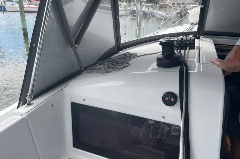 Slide: The Image of 2022 Jeanneau Sun Odyssey 440 yacht deck with winch and ropes in marina setting. - 25