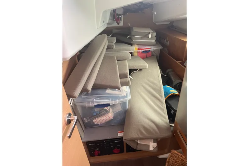 Slide: The Image of Interior storage area of 2022 Jeanneau Sun Odyssey 440 sailboat with cushions and containers. - 12