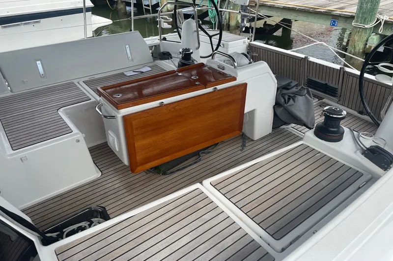 Slide: The Image of Cockpit of 2022 Jeanneau Sun Odyssey 440 sailboat with teak flooring and wooden table. - 19