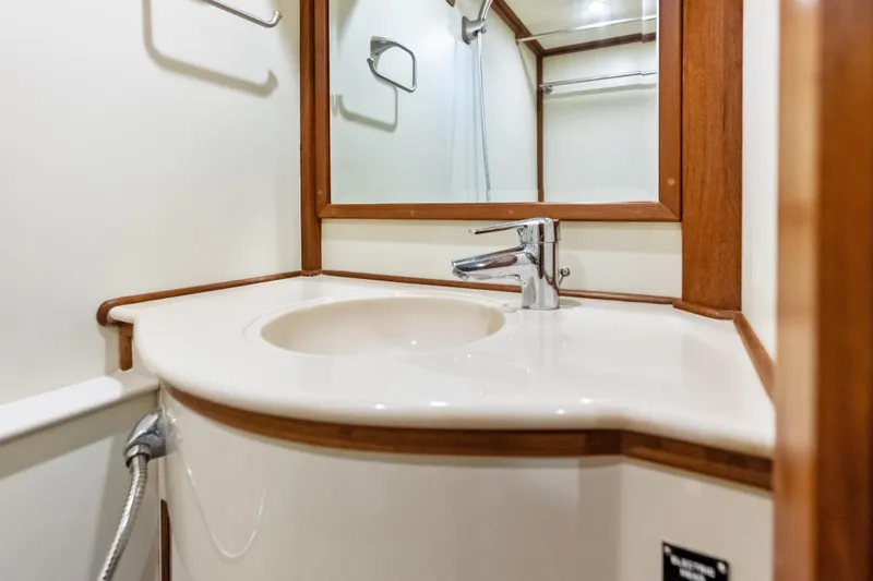 Slide: The Image of Luxurious bathroom sink on 2005 Grand Banks 72 Aleutian RP yacht, featuring elegant wood accents. - 155