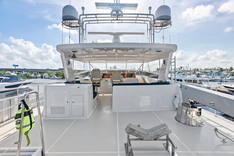 Slide: The Image of 2005 Grand Banks 72 Aleutian RP yacht deck with seating, marina view, and clear skies. - 127