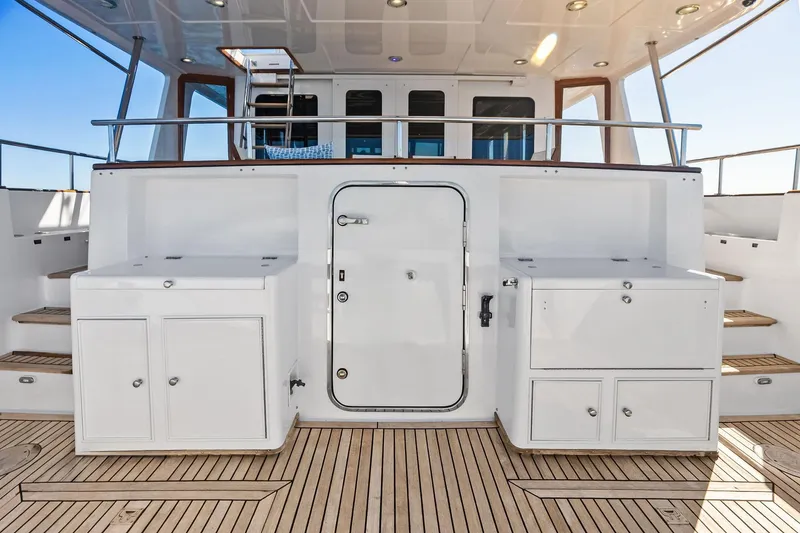 Slide: The Image of 2005 Grand Banks 72 Aleutian RP yacht deck with white cabinetry and wooden flooring. - 176