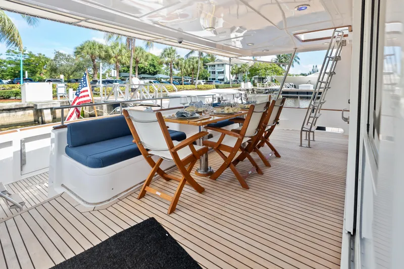 Slide: The Image of Outdoor dining area on 2005 Grand Banks 72 Aleutian RP yacht, featuring elegant seating and tableware. - 51