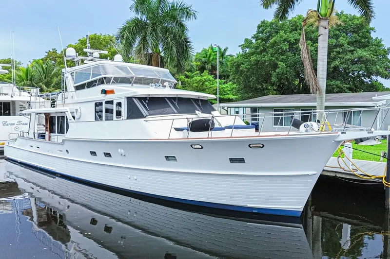 Slide: The Image of 2005 Grand Banks 72 Aleutian RP yacht docked near palm trees and waterfront homes. - 1