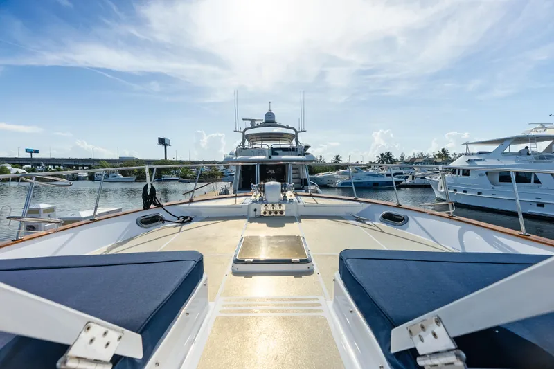 Slide: The Image of 2005 Grand Banks 72 Aleutian RP yacht docked, showcasing spacious deck and luxurious seating. - 119